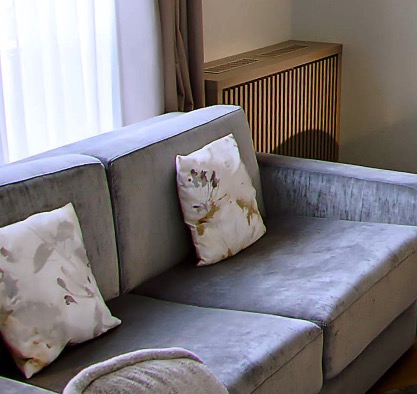 Grey velvet sofa with floral-pattern cushions
